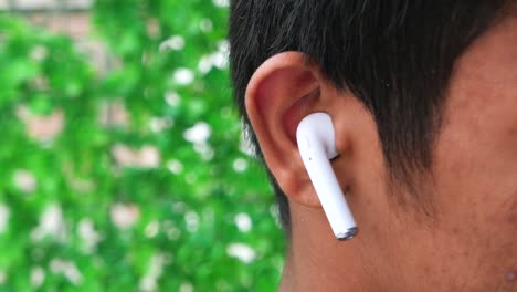 close-up of a person wearing white wireless earbuds