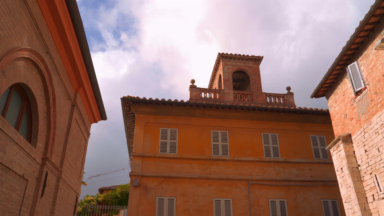Edifici storici colorati con facciate rosse e cielo azzurro a Perugia