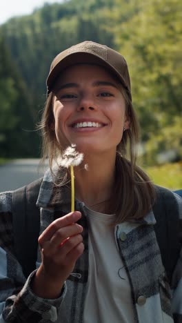 happy woman blowing dandelion in nature