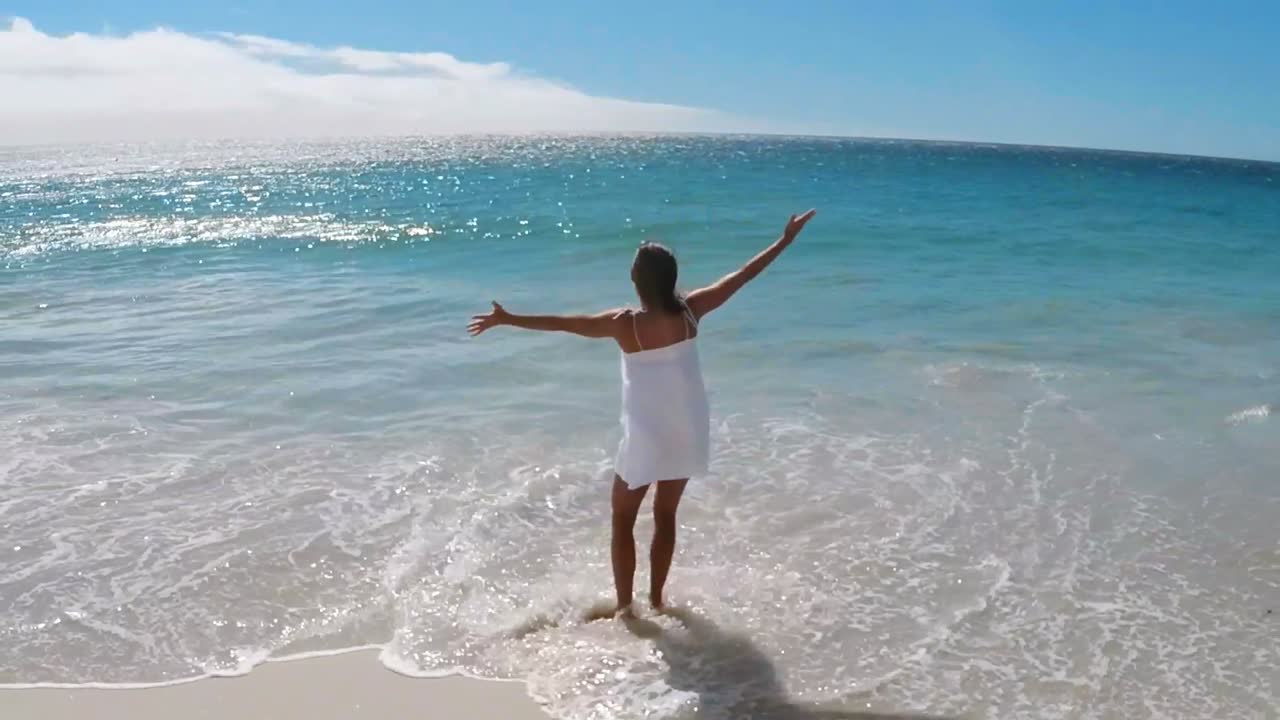 mujer estirando sus brazos en la playa