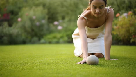 woman playing lawn bowling in a garden
