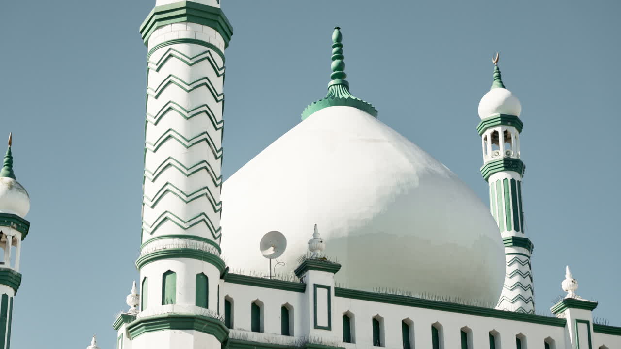 Mosque with a large white dome and green accents