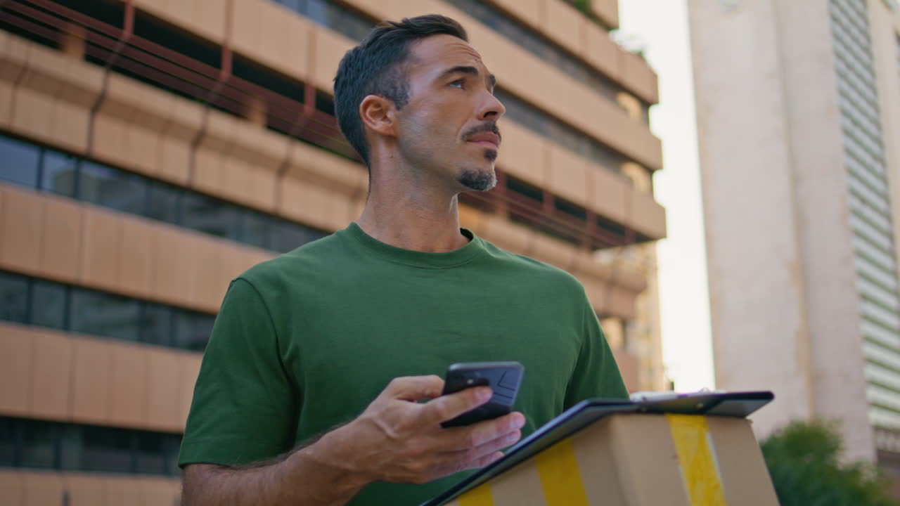 Confused courier looking around searching location at neighbourhood closeup