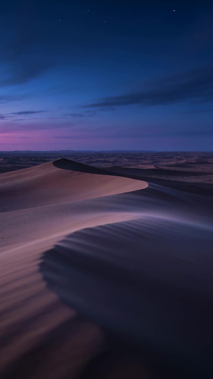 Video verticale: Orizzonte rosa che svanisce, cielo che si scurisce sopra una duna a mezzaluna nel deserto, stelle che appaiono
