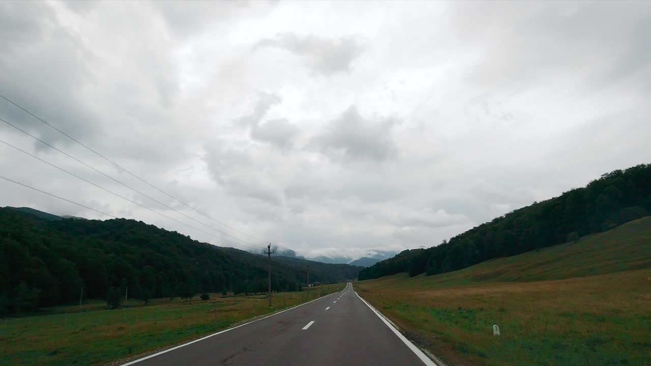 Scenic Country Road through Mountains on a Cloudy Day
