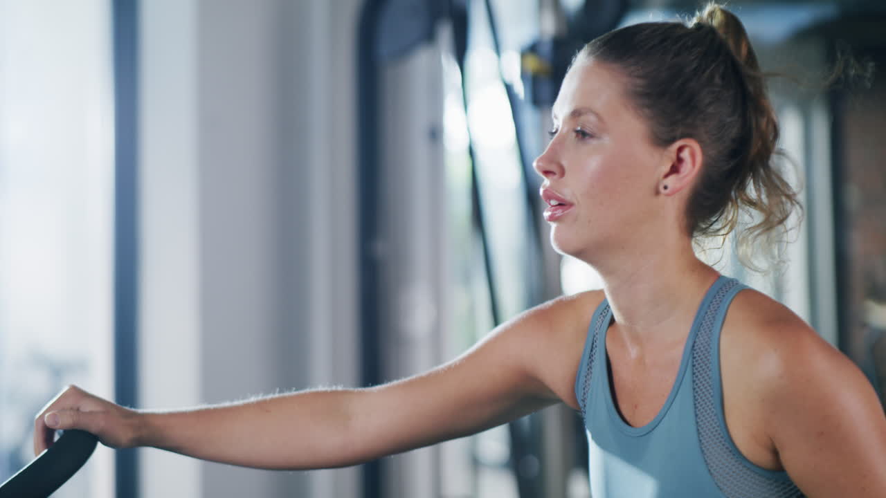 mujer trabajando en una máquina de remo en el gimnasio