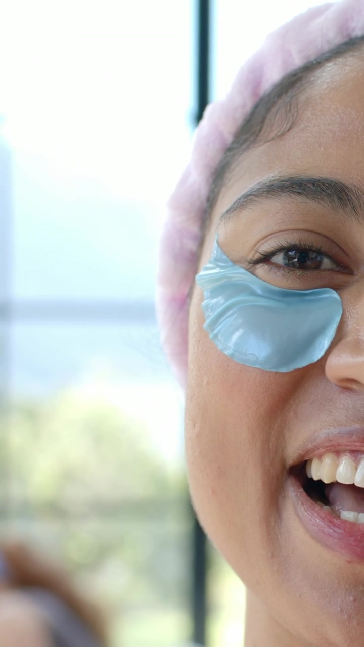 Video vertical: Mujer sonriente hablando en cámara desde casa, con diadema rosa, parche azul y espacio para texto.