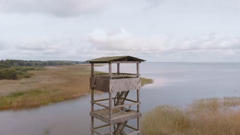 Drone-Aéreo-Volando-Sobre-La-Torre-De-Vigilancia-De-Madera-Del-Lago-Vortsjarv-En-Estonia,-Europa