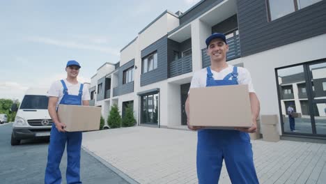 two young workers of removal company deliver boxes to a customer's home