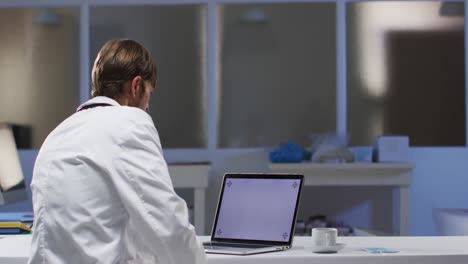 Caucasian-male-doctor-having-video-call-consultation-using-laptop