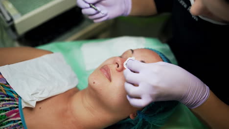 pore cleansing in the beauty salon. caucasian female is having the procedure of blackheads removal with the help of cosmetologist tool. top view.