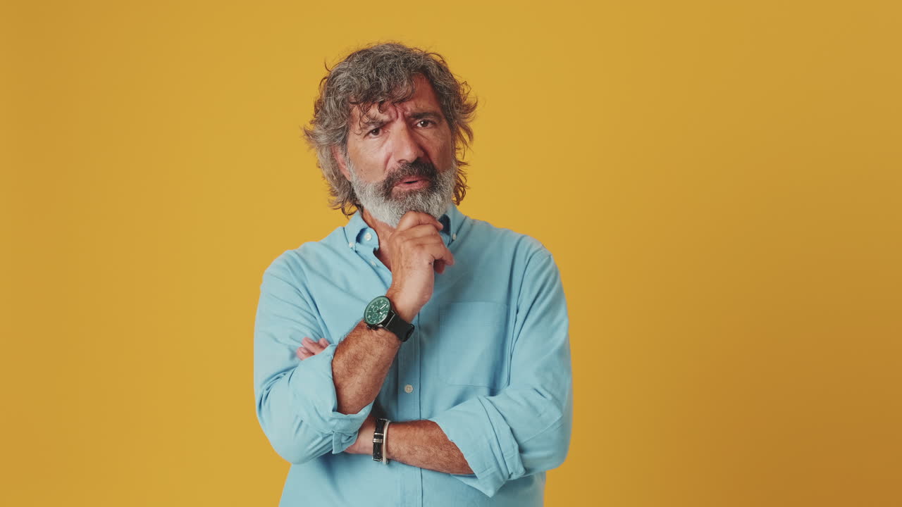 Thoughtful Mature Man Shakes Head No and Points Finger