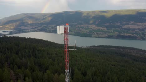 radio communications cell tower transmitter on a remote mountain overlooking wood lake