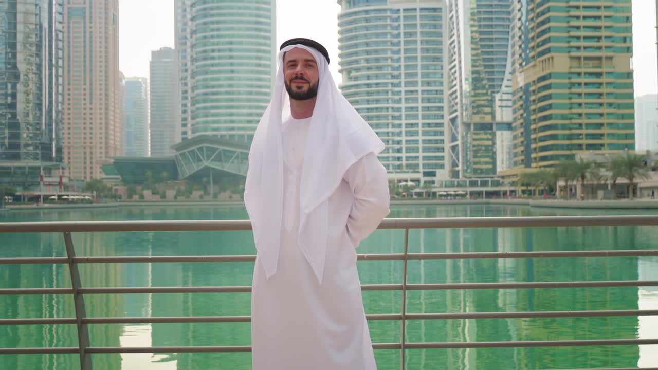Porträt eines Golf-Arabers in traditioneller emiratischer Kleidung, Türme und Wolkenkratzer an der Küste Dubais.