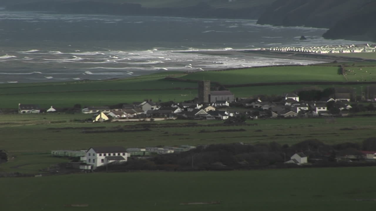 Un piccolo villaggio in Irlanda con la costa sullo sfondo.