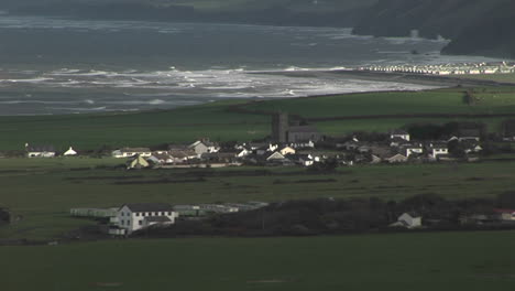 a small village in ireland with the coast background