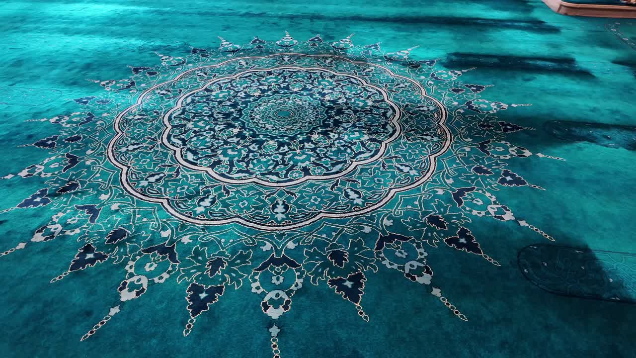 Tampak Dekat Karpet Berwarna Teal yang Berhias dengan Pola Islami yang Rumit