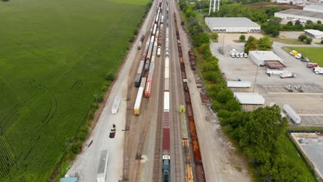 Vista-Aérea-De-4k-Que-Muestra-Varios-Trenes-Estacionados-En-Una-Estación-De-Tren-Esperando-Para-Salir