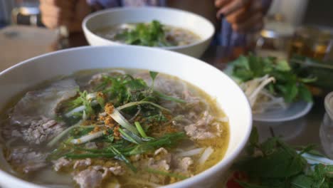 chica sexy en bikini comiendo sopa tradicional de fideos con ternera pho en un restaurante vietnamita local