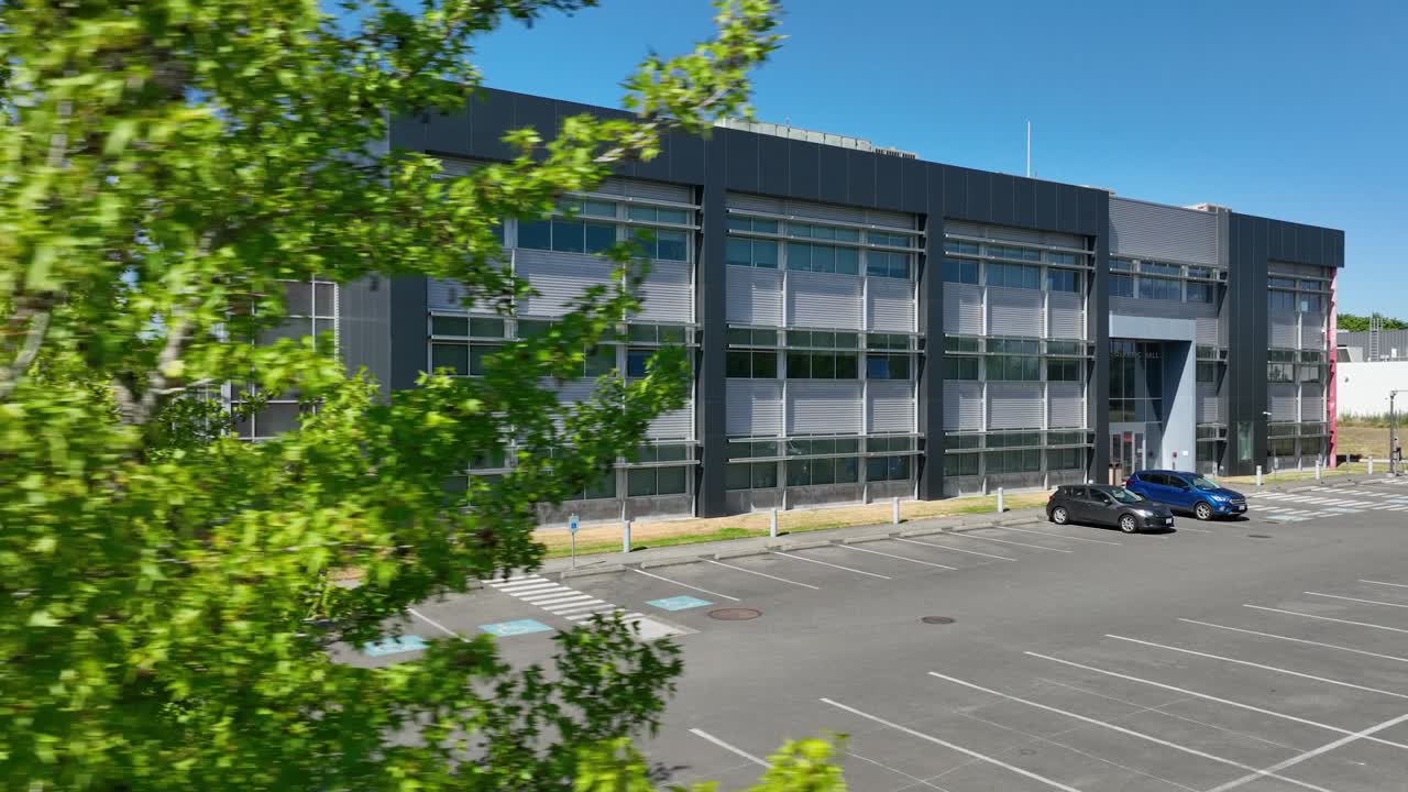 Aerial view revealing South Seattle College's Olympic Hall from behind a tree