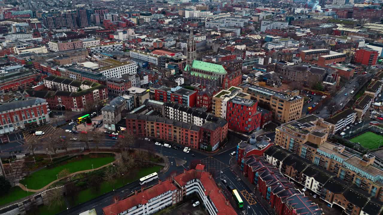 aerial drone shot of the general Irish capital of Dublin area with bustling streets full of traffic and tourists walking around the glowing streets at sunrise in winter with Irish architecture