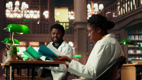 two medical school scholars focusing on their studies in a traditional library