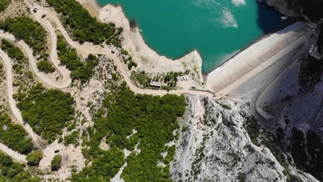ojo de pájaro aéreo sobrevolando el camino de acceso al lago bovilla, revelando aguas turquesas