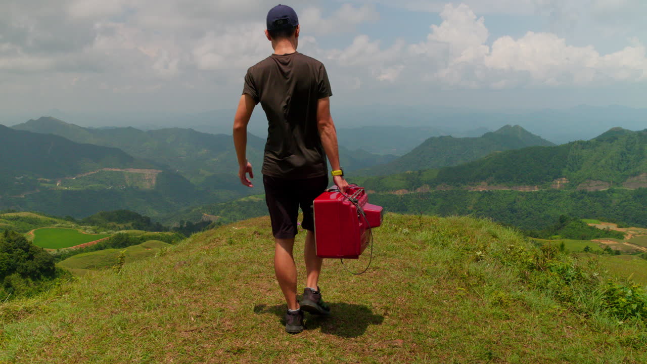 extraño video de un hombre llevando una vieja televisión en las montañas, contraste de tecnología y naturaleza