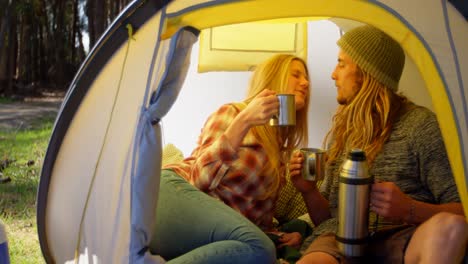 young couple kissing while having coffee in tent 4k
