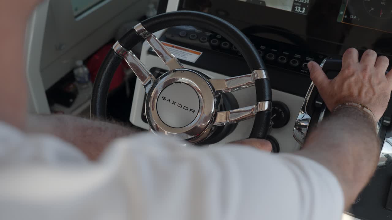 A man steers a luxury yacht on the azure waters of the French Riviera, enjoying the ultimate boating experience.