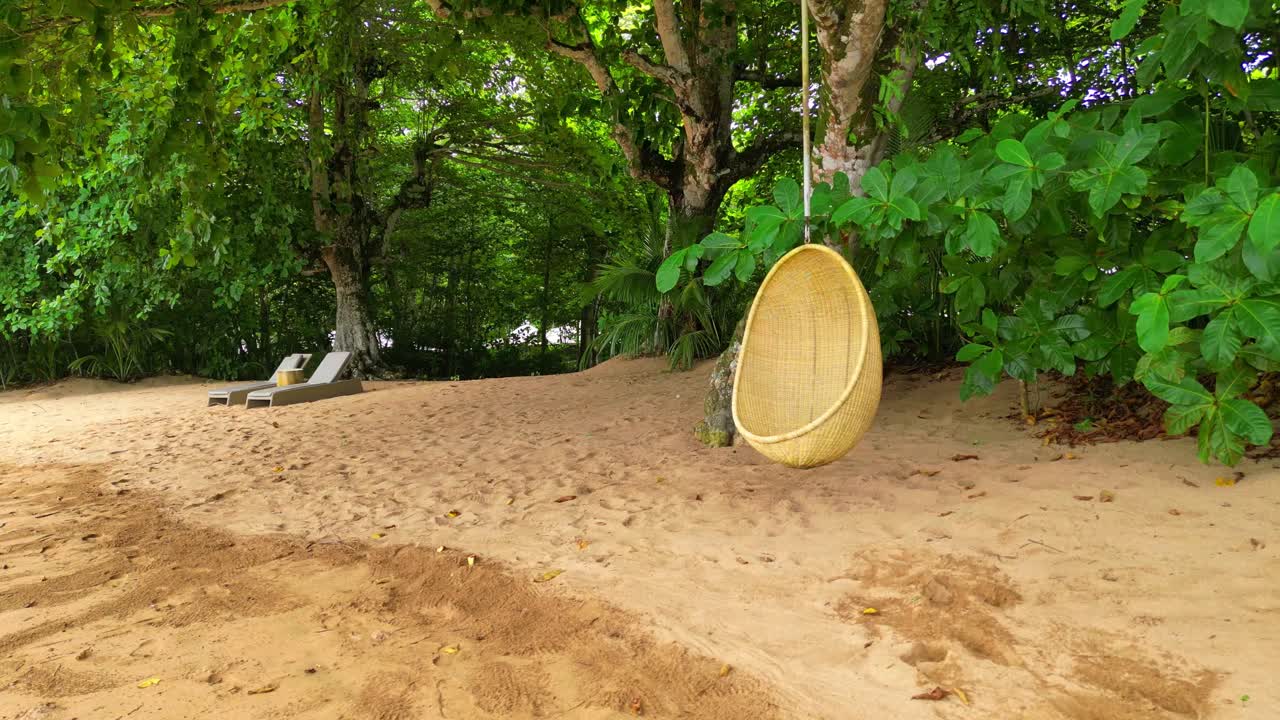 una vista de cerca desde una silla colgante y sillas de playa en una playa soleada en prince island, áfrica