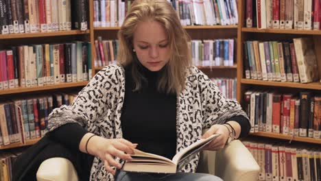 panning down shot of girl reading book in library