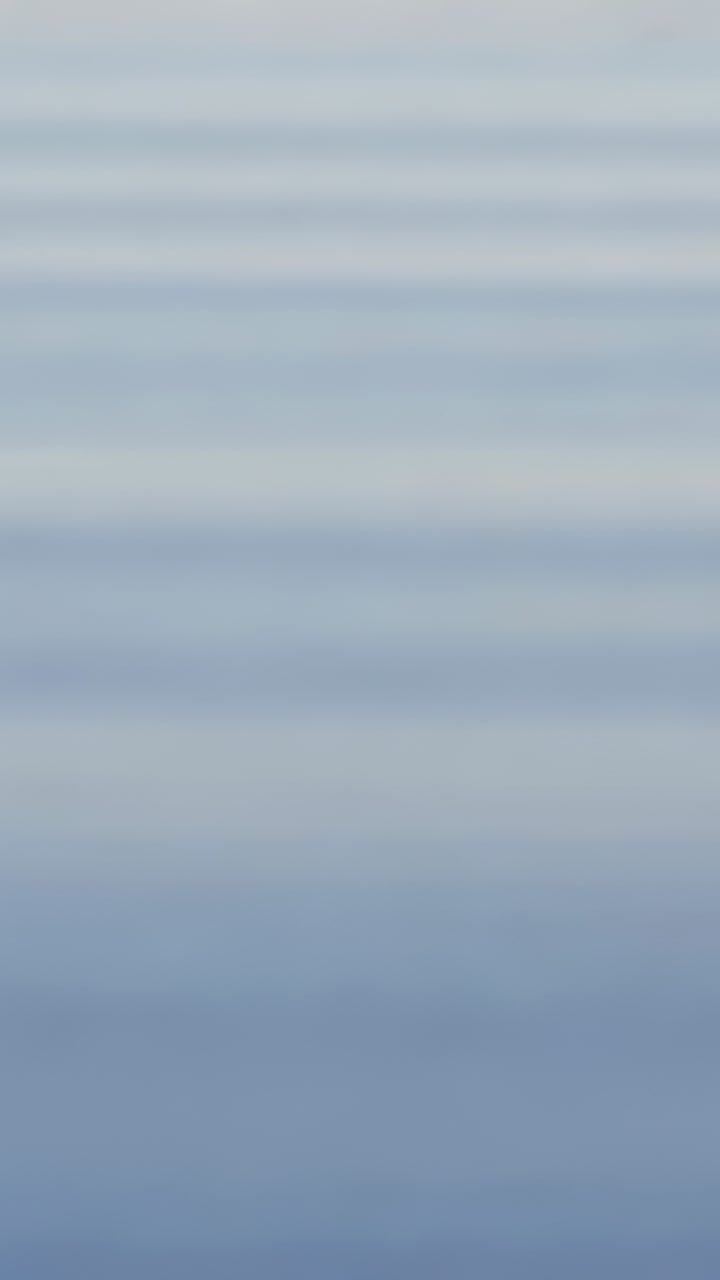 Vertical video: Passing wave stirring surface in tank, drops forming crown, rebound jets, ripples