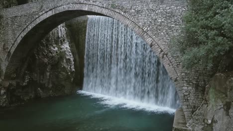 cascada y un viejo puente empedrado en un pequeño pueblo en grecia