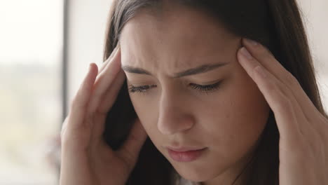 close up of a suffering woman having headache at home