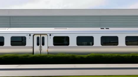 Side view of a sleek, modern train passing by, captured in a video style