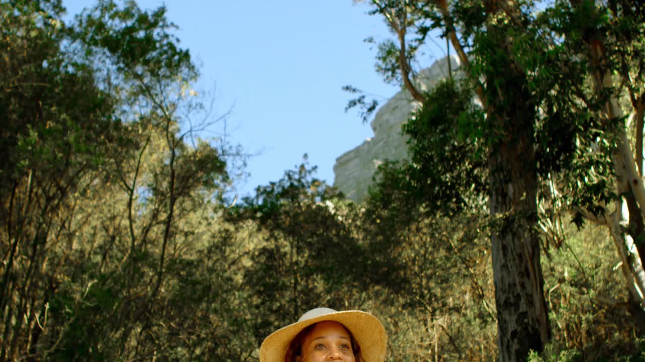 excursionista femenina de pie con las manos en la cadera en el campo 4k