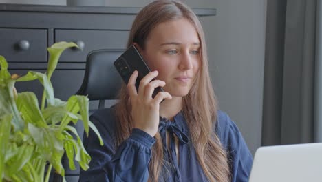 Young-woman-in-a-modern-office-talking-on-the-phone,-smiling-and-agreeing,-in-Slow-Motion