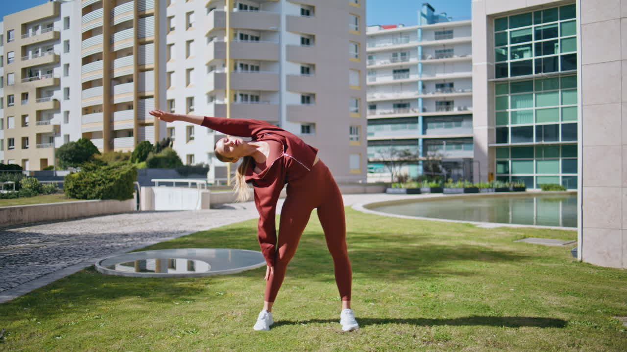 Sport woman stretching body in sunny morning. Active girl training in urban park