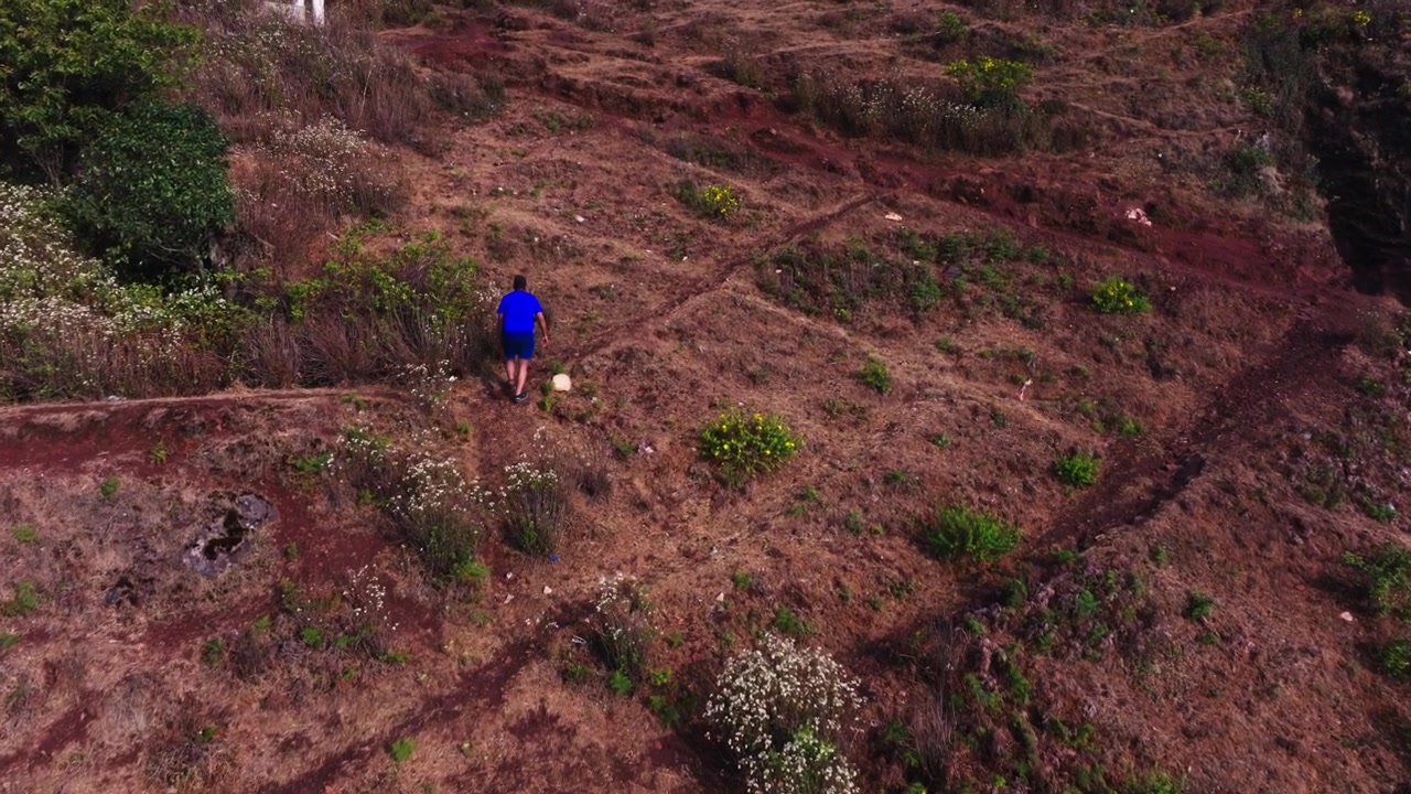 Pessoa fazendo trilha no pico Mullayanagiri com árvores ao redor e Mullayyana Giri Nandi Mantapa em Aralaguppe, Chikkamagaluru, Karnataka, Índia. Diurno, tomada em movimento, tomada de drone, 4K