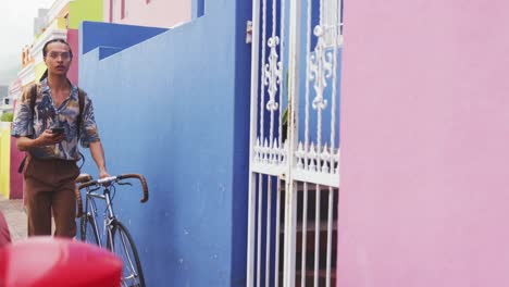 Mixed-race-man-walking-with-a-bike