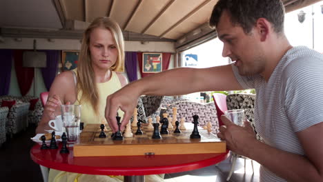una pareja sonriente jugando al ajedrez.