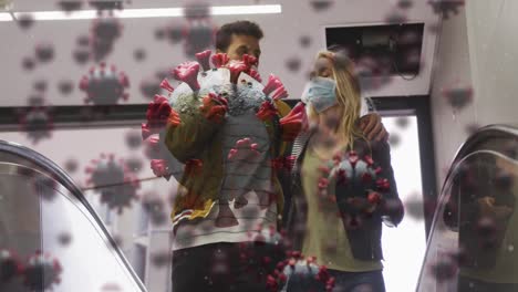 animation of virus cells over caucasian couple wearing face masks walking in street