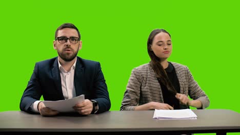 young beautiful tv presenter and stylish young man are hosting a news tv channel. the girl gets angry, throws the papers and the jacket she has taken off. leaves the frame. chromakey.