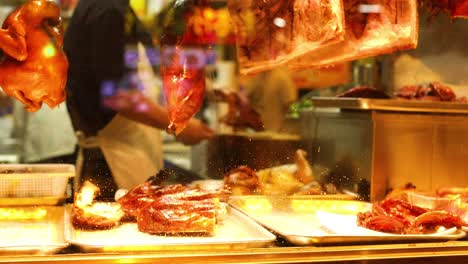 chef prepares roast duck at a food stall