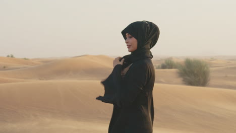 Porträt-Einer-Schönen-Muslimischen-Frau-Mit-Hijab,-Die-In-Einer-Windigen-Wüste-Spazieren-Geht-Und-In-Die-Kamera-Schaut-3