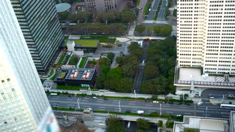 time-lapse - looking straight down from tall building on street, traffic and people walking in city