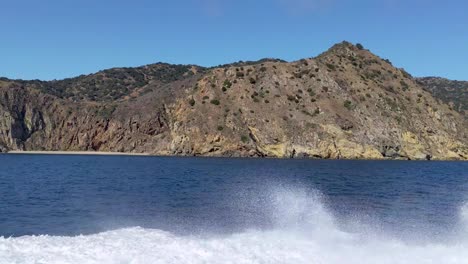 catalina island shoreline from the water ferry with boat and wake