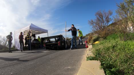 male pit workers waiting for racing cars to check at the pit stop in malta - closeup gopro shot