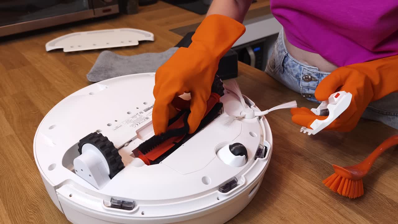 Woman Cleaning a Robot Vacuum Cleaner